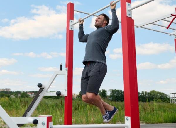 middle-aged man doing pull-ups