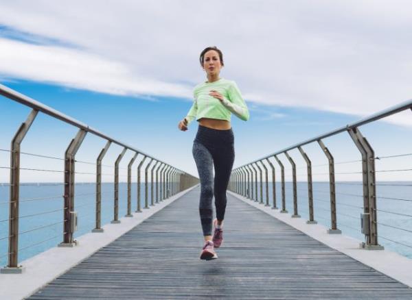 woman sprinting, running down pier, co<em></em>ncept of bad fitness habits that destroy your body after 30