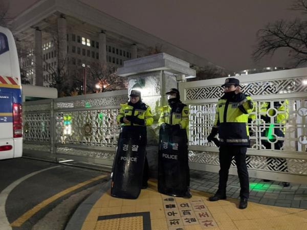 Policemen stand in front of the gate to the Natio<em></em>nal Assembly