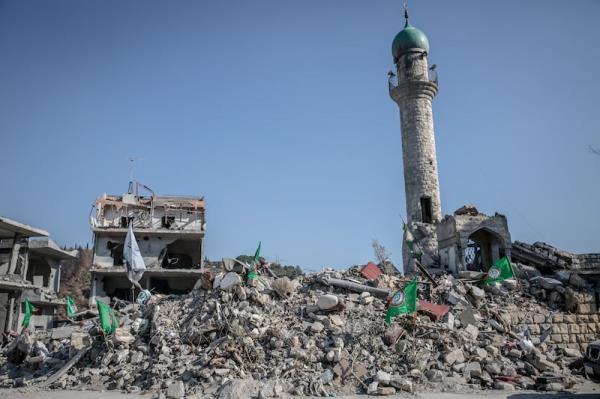 
The remains of the town square in Kherbet Selem, wher<em></em>e a minaret from the mosque is the o<em></em>nly part of the centre left standing, and the flag of the Hizbullah-aligned Amal Movement is planted in the rubble. Photograph: Sally Hayden