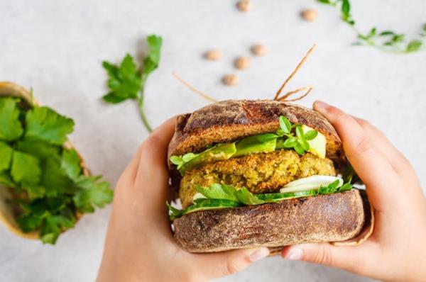 Person holding vege burger in hand