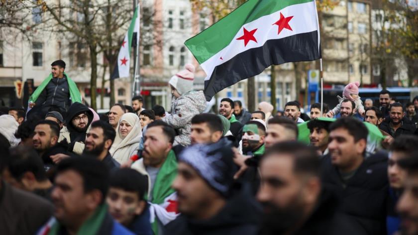 Syrians wave Syrian opposition flags at a rally in Wuppertal, Germany, Dec. 8, 2024. (AP Photo)