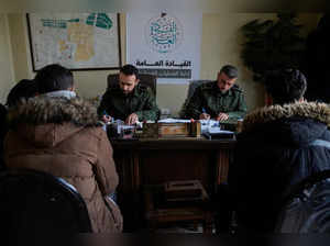 Rebels, led by the group Hayat Tahrir al-Sham, talk with what they say are members of Syrian President Bashar al-Assad's forces