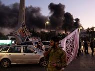 Smoke billows as people gather to celebrate the fall of the Syrian government, in Damascus on December 8, 2024. (Ugur Yildirim/Dia Photo via AP)