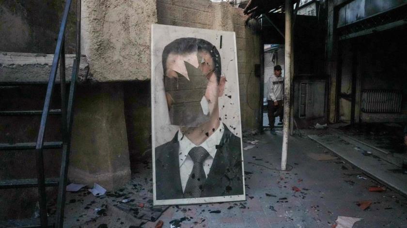 A defaced portrait of Syria&#039;s Bashar Assad stands in a ransacked government security facility, in Damascus, Syria, Dec. 8, 2024. (AFP Photo)